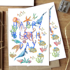 Happy birthday greetings card with underwater animals and fish flatlay